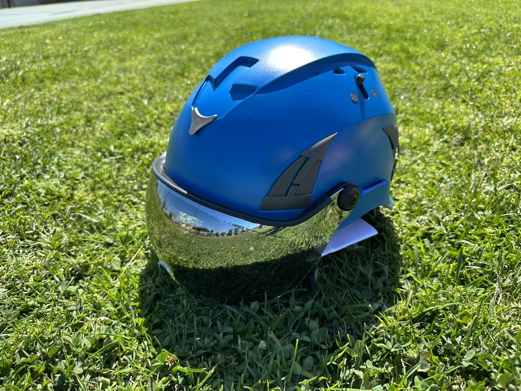 Blue AeroPro Safety Helmets with Smoke Visor Kit on Grass. ANSI/ISEA Z89.1-2014 Type 1 Class C Safety Helmet with Smoke Visor used for Construction, Rescue & Arborist.