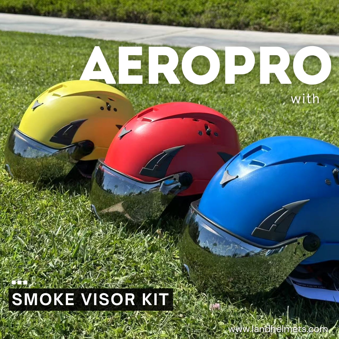 3 AeroPro Safety Helmets with Smoke Visor Kit, colors yellow, red and blue on Grass. Three ANSI/ISEA Z89.1-2014 Type 1 Class C Safety Helmets with Smoke Visor used for Construction, Rescue & Arborist.